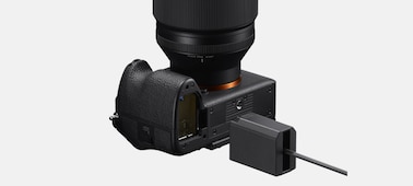 Obrázek produktu zobrazuje tělo fotoaparátu α7R VI s konektorem a adaptérem simulujícím baterii NP-SA100