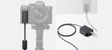 Ilustrace zobrazuje připojení modelu DC-C2 k USB napájení v síťové zásuvce a konektor zapojený do těla fotoaparátu
